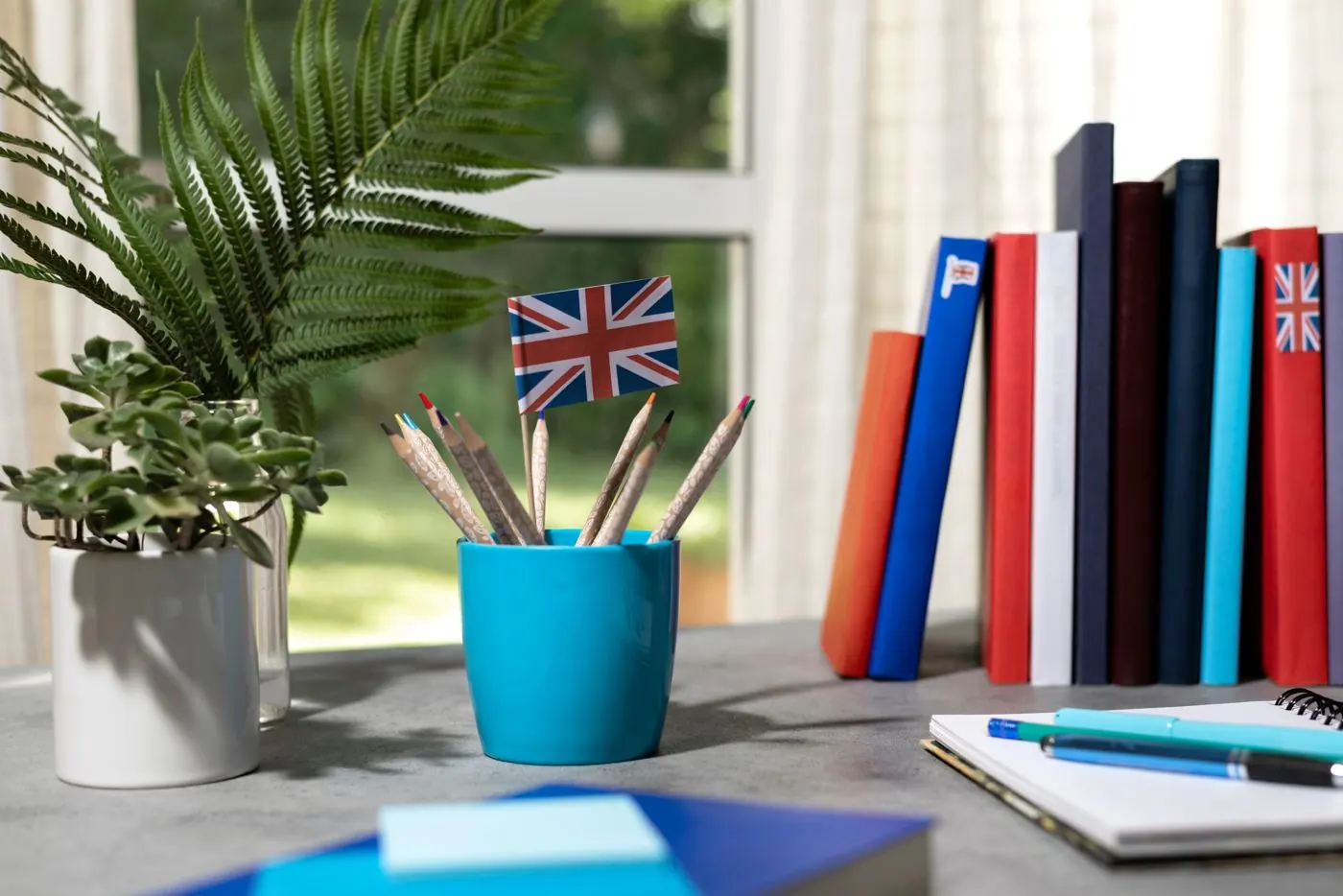 Bureau avec livres, crayons et un petit drapeau britannique